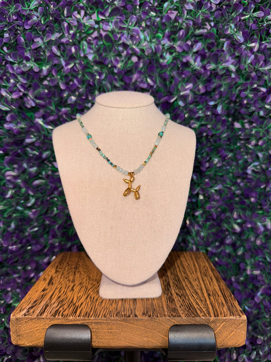 Balloon Dog Charm Necklace — product photo 2. A gold-tone balloon dog charm on an aqua faceted bead chain with gold-tone spacers.