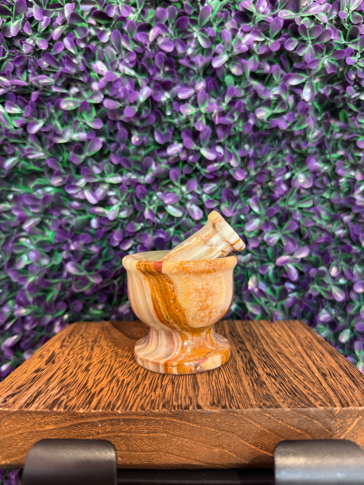 Another angle of the matching mortar and pestle against purple foliage.