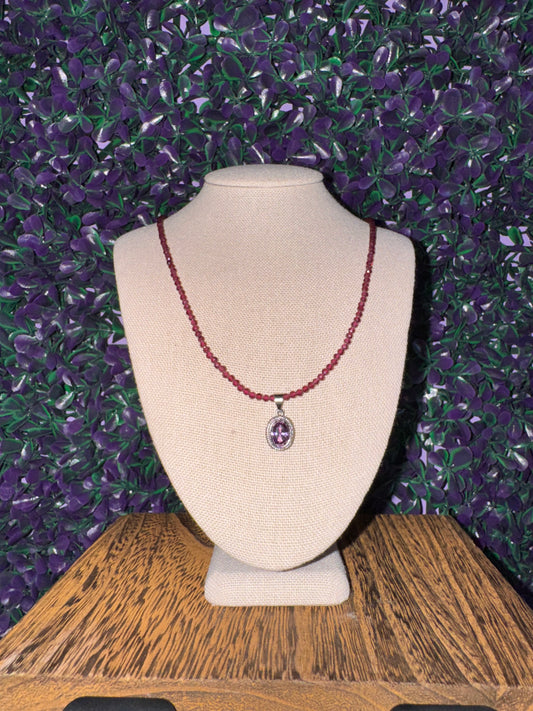 Lavender Oval Halo Pendant Necklace — product photo 2. A faceted lavender oval pendant in a silver-tone halo setting with clear accents, paired with a deep red faceted bead chain.