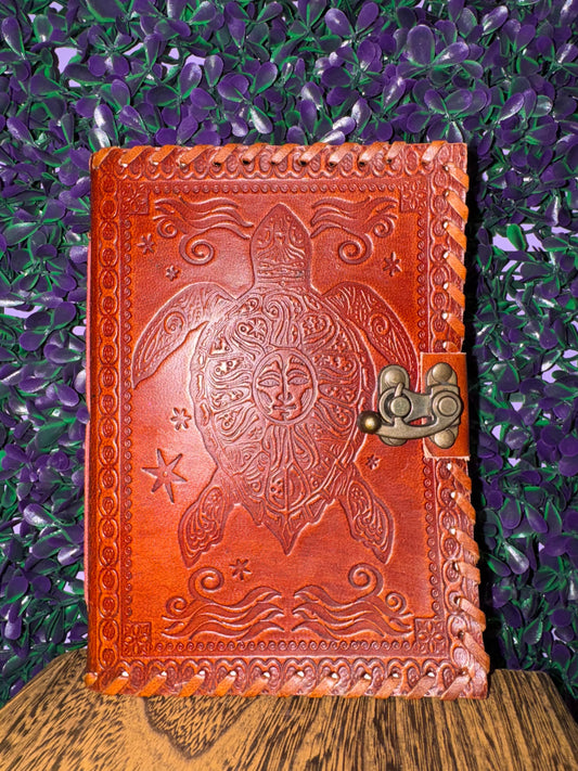 Front cover of the sea turtle journal showing the sun face on the turtle's shell.