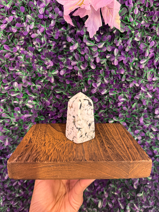 Black-Spotted Cream Stone Tower — product photo 1. A polished cream-colored stone tower with black spots and a pointed, faceted top.
