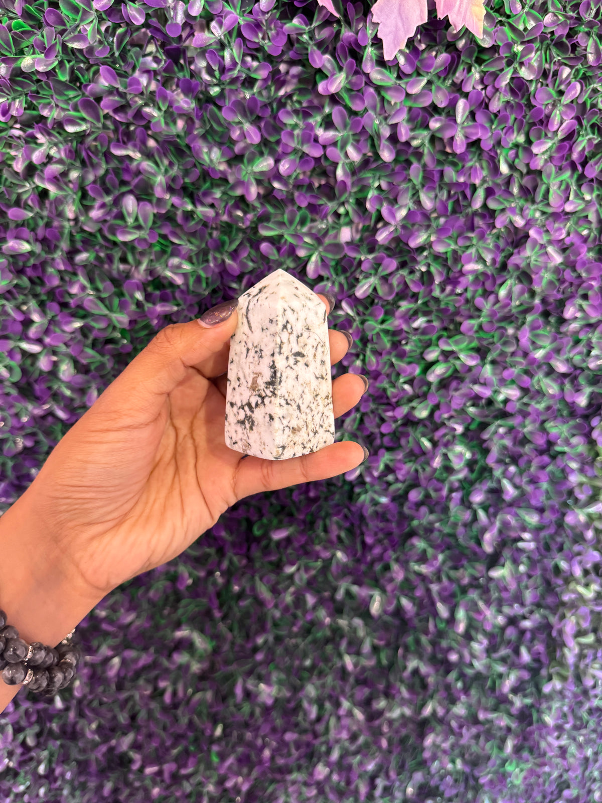 Black-Spotted Cream Stone Tower — product photo 3. A polished cream-colored stone tower with black spots and a pointed, faceted top.