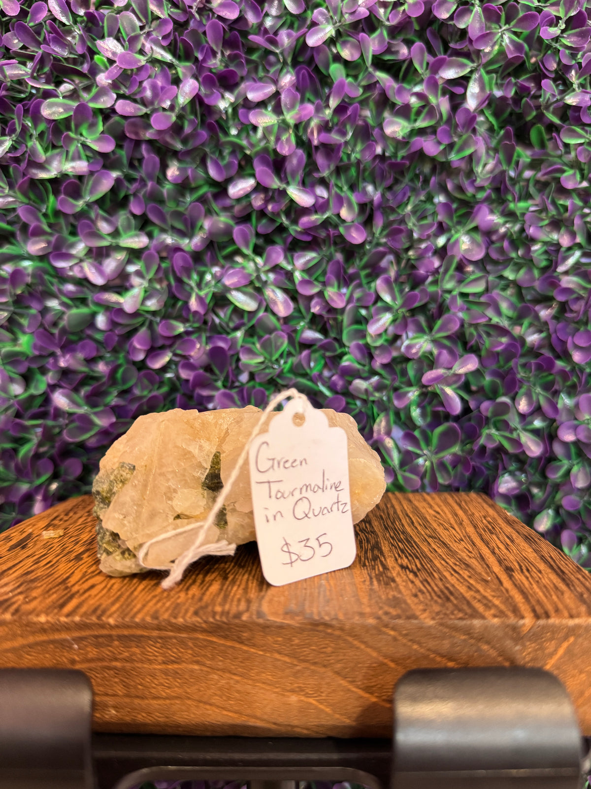 Green tourmaline in quartz specimen with a handwritten tag reading Green Tourmaline in Quartz $35.