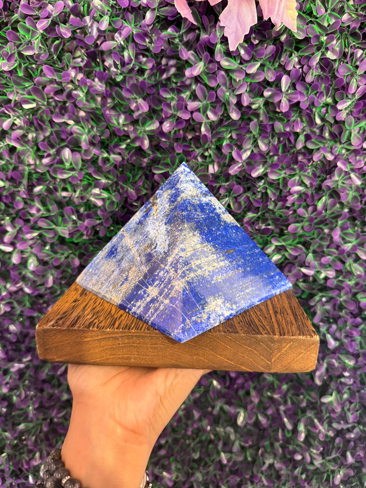 Wider view of the lapis lazuli pyramid against purple foliage.