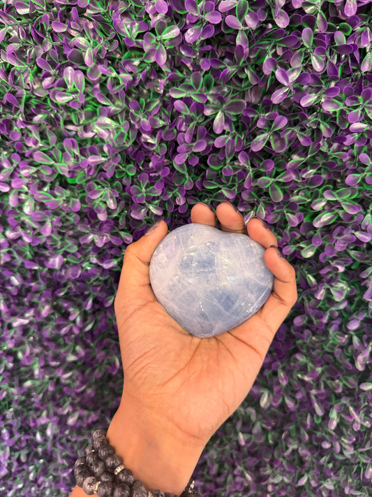 Pale Blue Heart Palm Stone — product photo 1. A smooth, puffy heart-shaped palm stone in soft pale blue, with cloudy white markings.