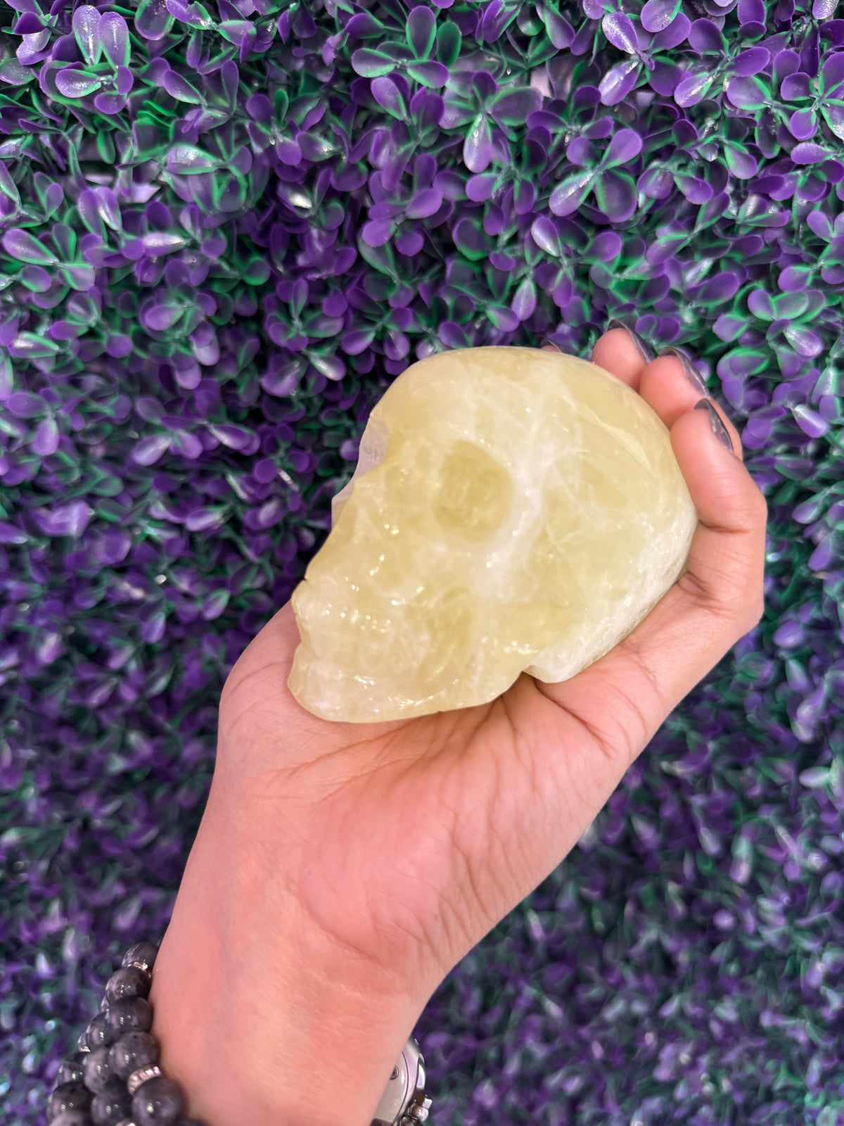 Pale Yellow-Green Skull Carving — product photo 3. A smooth, polished skull carving in translucent pale yellow-green tones, with softly carved features.