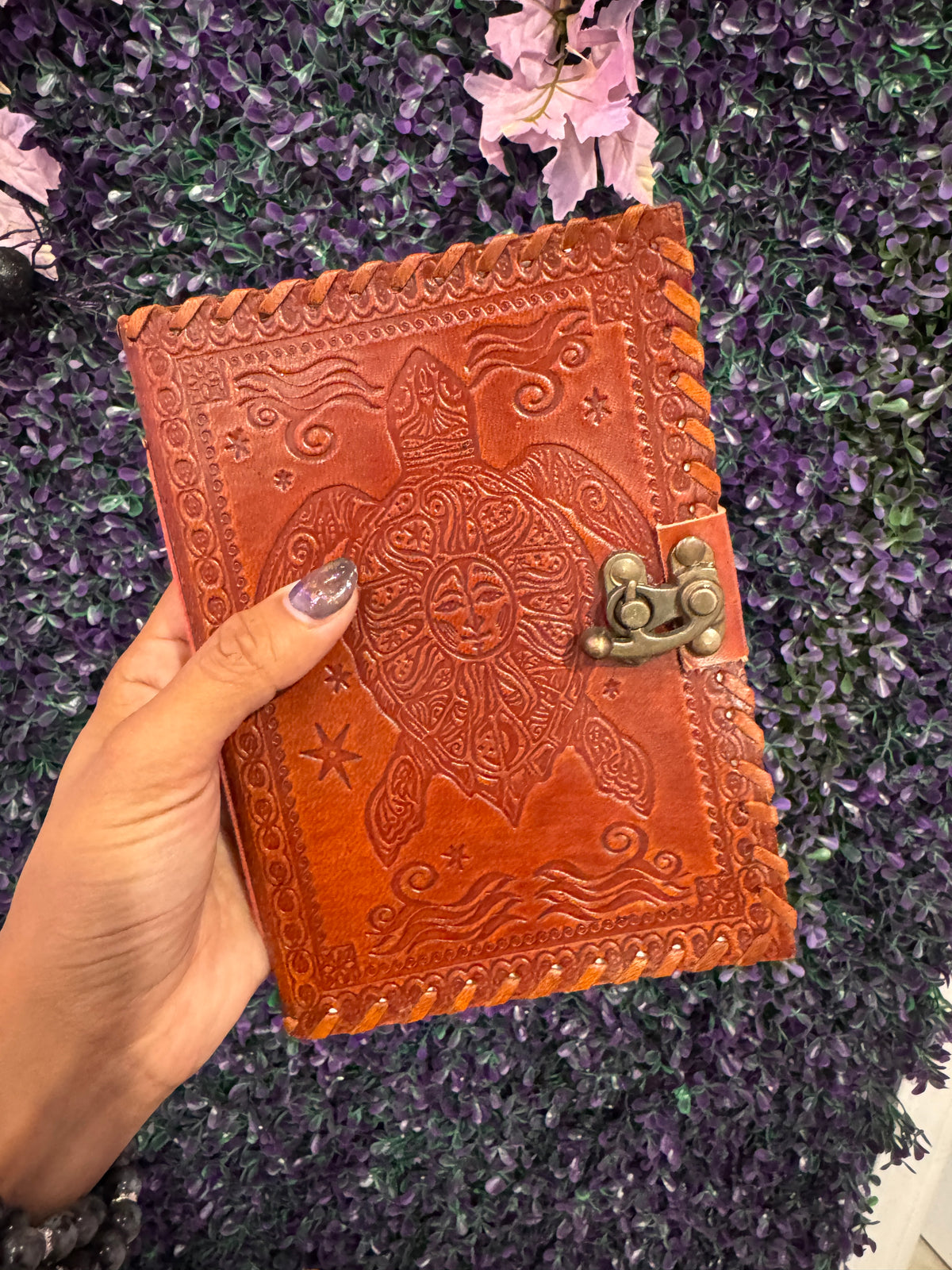 Hand holding the sea turtle journal to show its size.