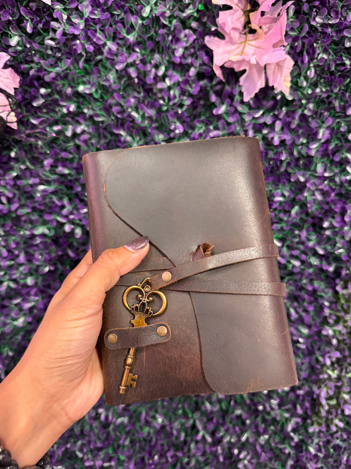 Hand holding the skeleton key wrap journal to show its size.