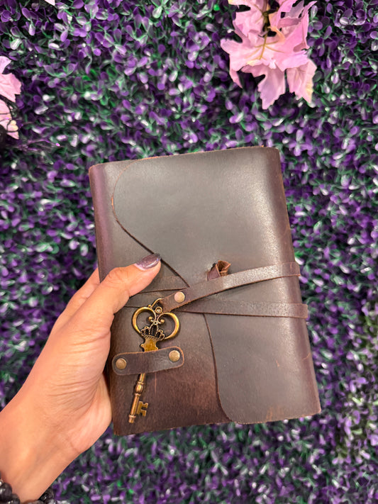 Hand holding the skeleton key wrap journal to show its size.