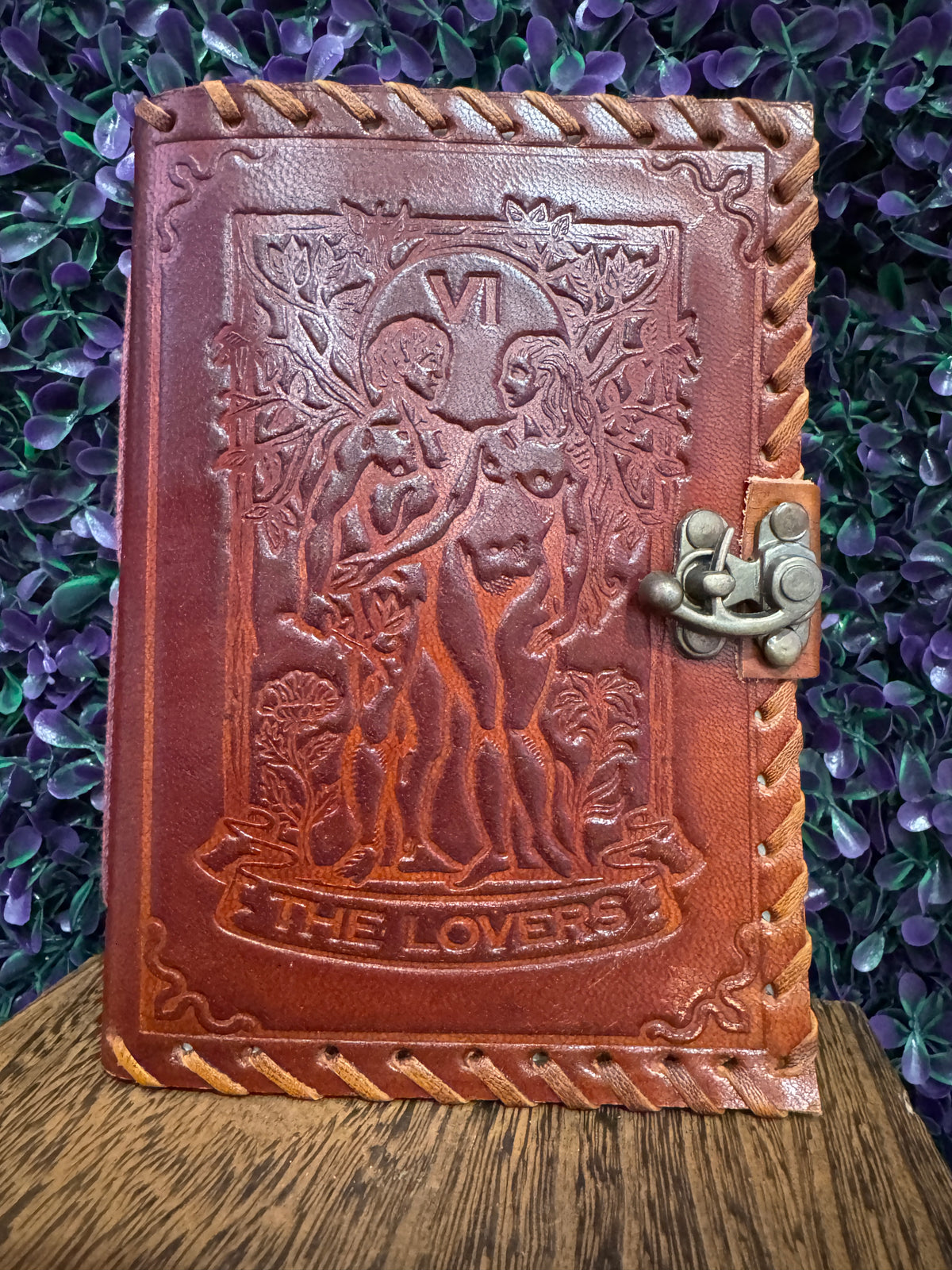 Straight-on view of The Lovers tarot journal cover with two figures and trees.