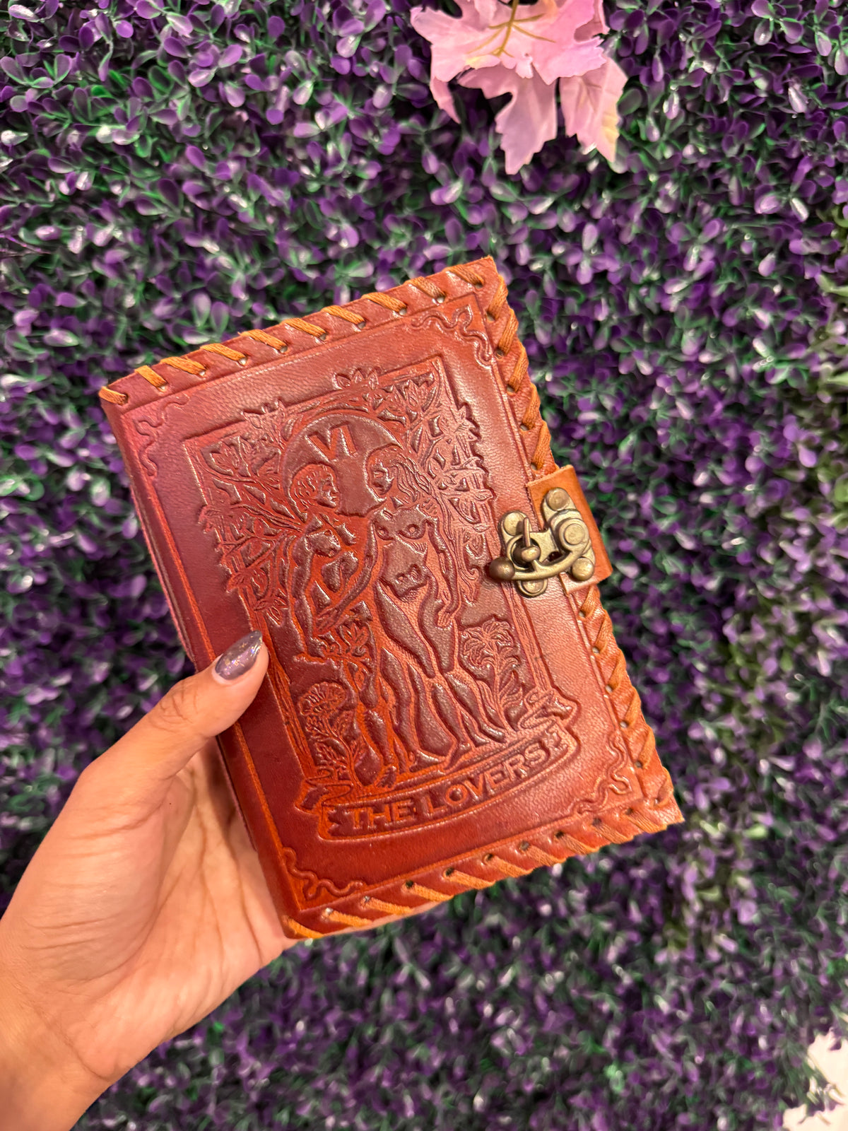 Hand holding The Lovers tarot journal to show its size.