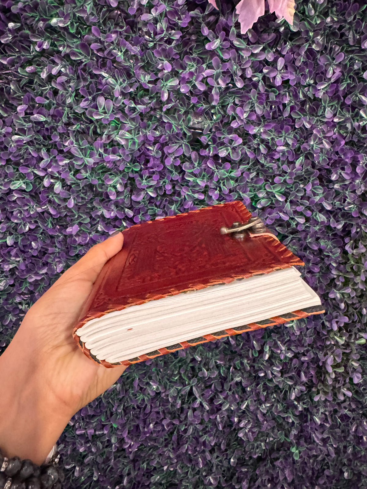 Side view of The Moon tarot journal held in hand, showing its thick cream page block.