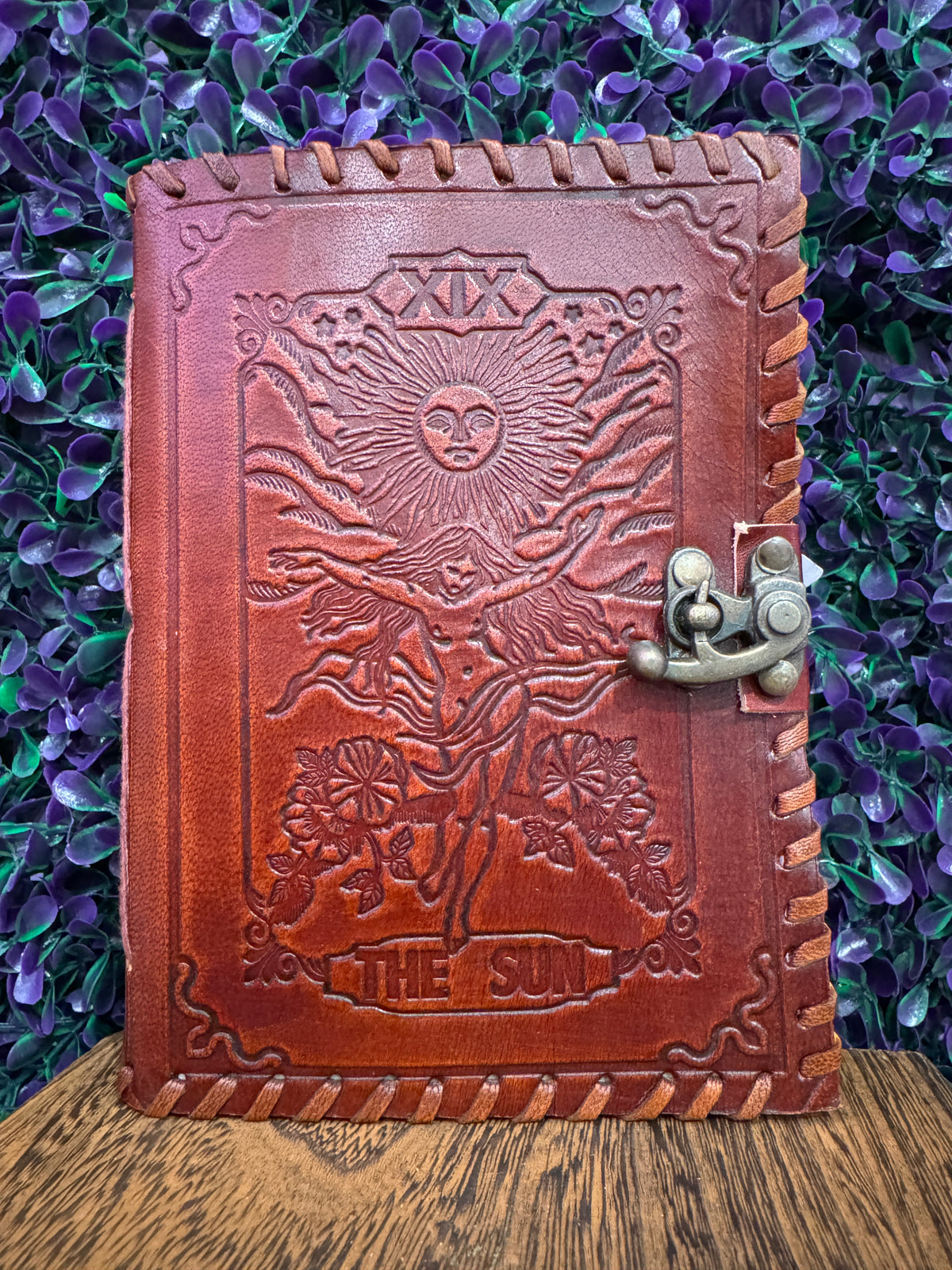 Red-brown embossed journal with The Sun tarot card design and a brass-tone clasp.