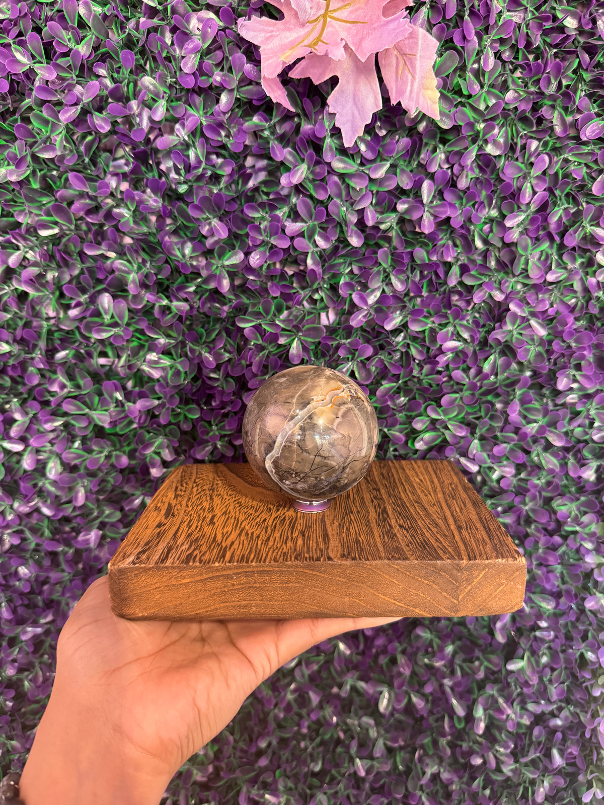 Volcano agate sphere on a small stand showing mottled gray brown and cream patterning.